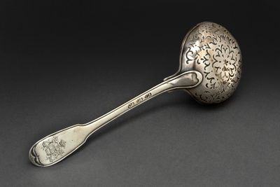 cuillère en argent ornée d'un motif décoratif sur un fond noir