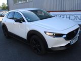 the white mazda cx - hr is parked in front of a building
