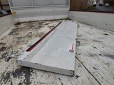 a piece of concrete laying on the ground in front of a building