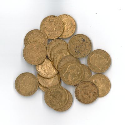 une pile de pièces d'or posée sur une surface blanche