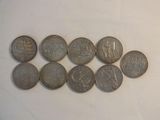 several coins are arranged in a row on a white surface