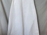 white dress with pink trim on a hanger on a gray background