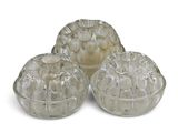 three clear glass containers with lids on a white surface