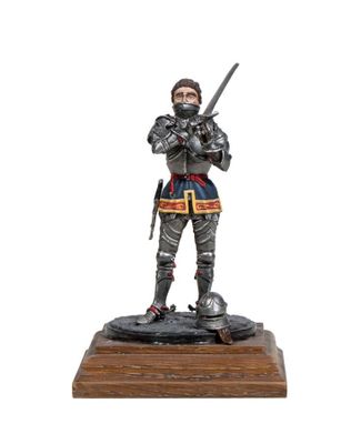 a figurine of a knight holding a sword on a wooden base