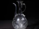 an old glass vase with a handle on a black surface