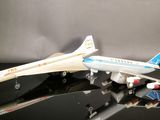 two model airplanes sitting on a black surface
