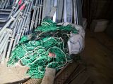 a pile of fishing nets on the ground in front of a fence