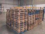 pallets stacked on pallets in a warehouse with a ladder in the background