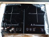 une plaque de cuisson noire dans un carton posé sur une table