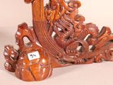 a wooden sculpture of a dragon and a ball on a table