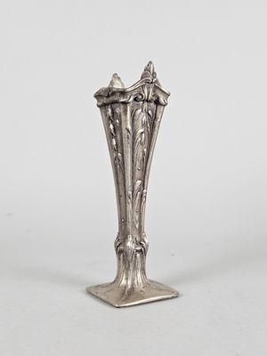 un vase ancien en argent posé sur un socle, sur fond blanc