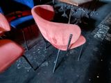 brightly colored chairs and a table in a dark room with a neon sign