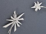 two small metal starbursts that are on a table