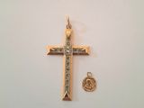 une croix en or et un pendentif en forme de cœur en or sur un fond blanc