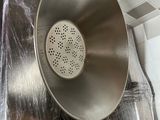 a large metal strainer hanging from the ceiling in a kitchen
