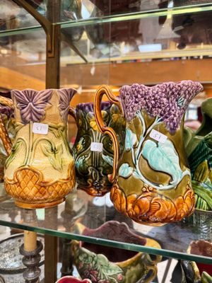 many vases that are on display in a glass case