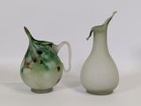 deux vases posés l'un à côté de l'autre sur une surface blanche