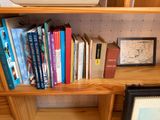 many books on a wooden shelf in a room