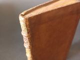 a small brown book sitting on top of a table