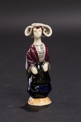 figurine représentant une femme avec un chapeau et un sac