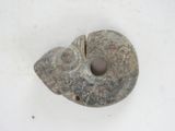 a stone object with a hole in it on a white surface