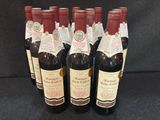 six bouteilles de vin rouge sont alignées sur une surface noire