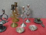 de nombreux types de bougeoirs en argent posés sur une table