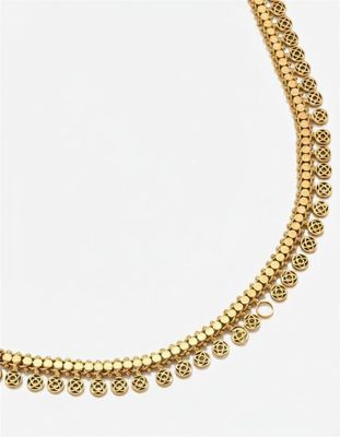 gros plan d'un collier en or sur fond blanc