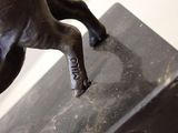 a statue of a horse that is standing on a marble block