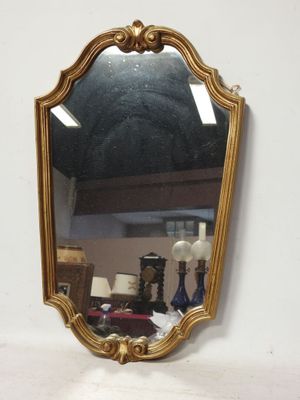 un miroir accroché au mur à côté d'une lampe