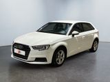 L'Audi blanche est garée dans une grande pièce blanche.