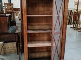 un meuble en bois avec une porte en verre au milieu d'une pièce