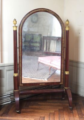 un miroir posé sur un pied dans un coin de la pièce