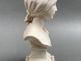marble bust of a woman wearing a headscarf on a marble base