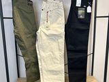 deux paires de pantalons pour homme suspendues à un portant dans un magasin