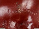 a close up of a red vase with writing on it