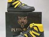 une paire de baskets montantes noires et jaunes dans une boîte