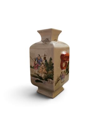 a small vase with a painting on it on a white surface