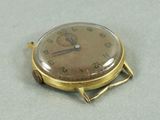 une montre en or posée sur une table blanche
