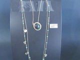two necklaces on display on a black display stand