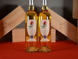 two bottles of wine sitting on a table next to each other