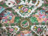 a decorative plate with flowers and birds painted on it