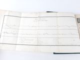 an old book with a line graph on it sitting on top of a table