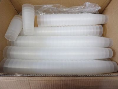 a cardboard box with a bunch of white plastic cups in it