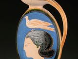un vase surmonté d'une image représentant une femme et un oiseau