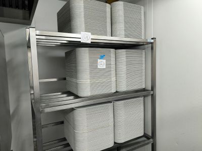 a metal shelf that has several bins on top of it