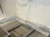 a small room with a metal floor and a phone on the wall