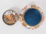 a blue bowl with a painting on it next to a box