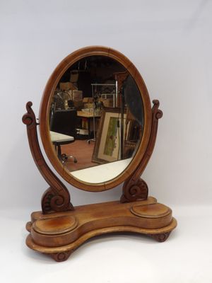 un miroir posé sur un support, lui-même posé sur une table