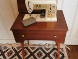 une machine à coudre posée sur une petite table dans une pièce
